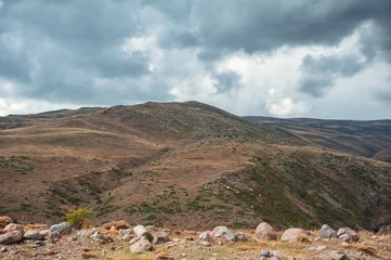  Dramatic mountain valley under a cloudy sky with a rugged landscape © darkbird