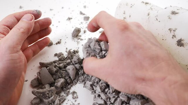 Men's hands take a plaster glass out of the silicone molding. Defective gypsum product. crumbles