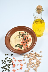 Brown bowl with hummus, seeds, and sprinkles