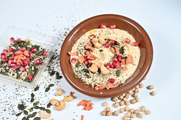 Brown bowl with hummus, seeds, and sprinkles