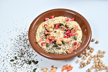 Brown bowl with hummus, seeds, and sprinkles