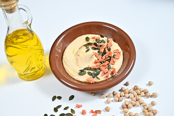 Brown bowl with hummus, seeds, and sprinkles