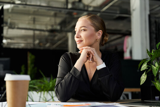A young beautiful plus size woman in an office setting reflects while working at her desk.