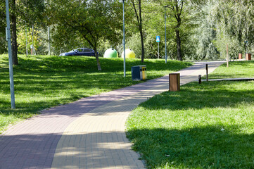 Walkway surrounded by trees and lawns in Kyiv, Europe. Recreation place in the city park