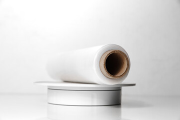 a roll of packaging stretch film on a white table. Convenient packing and transport material for groceries or moving.