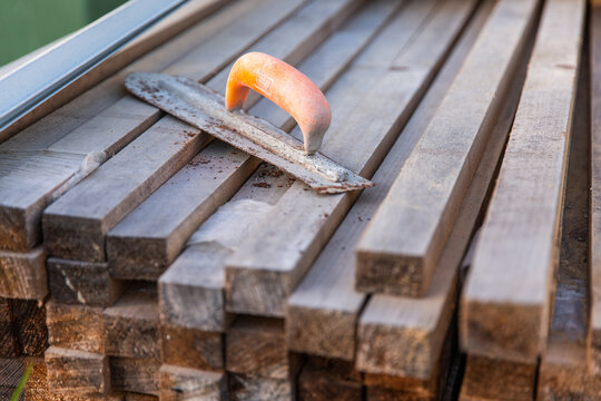a dirty trowel sitting on timber at a construction site