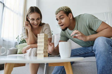 Friends engage in a playful game of Jenga while sharing laughter together.