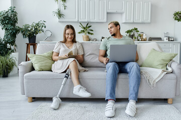 A non binary person shares a relaxed moment with a friend on the sofa.