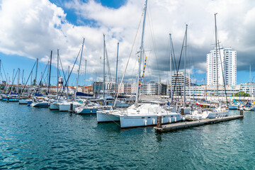 Obraz premium A view along jetties in the marina at Ponta Delgada on the island of San Miguel in the Azores in summertime