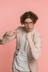 Quarrel. Displeased young man gesturing hands with irritation and displeasure, blaming scolding for failure, asking why this happened. Brunette attractive guy isolated on pink studio background