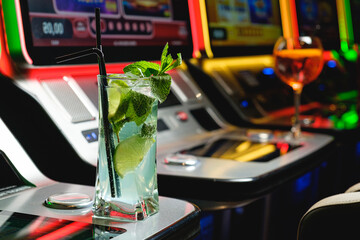 Mojito coctail on the background of slot machines in a casino. Casino concept.