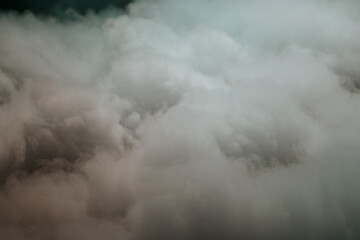 Obraz premium A detailed close up of a cloudy sky showcasing swirling smoke rising ominously from the clouds, creating an eerie atmosphere