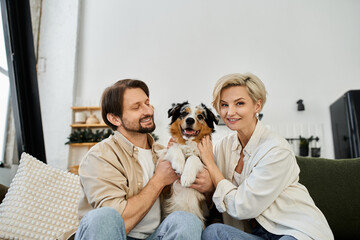 This couple shares laughter at home with their adorable furry friend in a joyful setting.