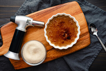 Close-up of Coffee creme Brulee with Torch and Sugar: Torched coffee creme brulee with a kitchen...