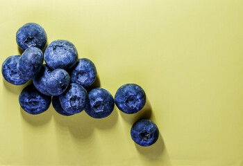 Fresh blueberries on a pastel yellow background create a vibrant, minimalist banner perfect for healthy food themes.