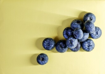 Fresh blueberries on a pastel yellow background create a vibrant, minimalist banner perfect for healthy food themes.