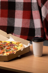 A delicious pizza with sliced tomatoes, red onions, and green herbs in an open cardboard box on a wooden surface. Perfect for food delivery themes and casual dining