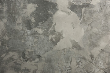 Close-up of microcement texture with various shades of gray and a rough, uneven surface. Ideal for showcasing modern interior design and architectural details.