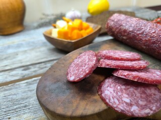 Wooden cutting board with sliced salami. High quality photo