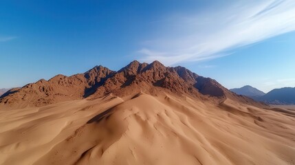 Desert mountain range, aerial perspective, dry and rugged terrain, sand dunes, midday sun, mountain aerial view, arid beauty, wilderness