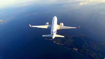 Aerial View of Passenger Airplane Flying Over Ocean and Coastal Landscape. Video. Horizontal.