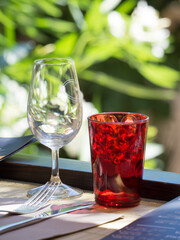 A white glass and a red glass on a restaurant table in the village of Eze, France