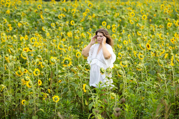 Fototapeta premium A Woman in White in a Field of Sunflowers: A Moment of Serenity Among Yellow Blossoms