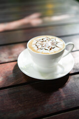 In the morning  hot latte art coffee is served on a wooden table