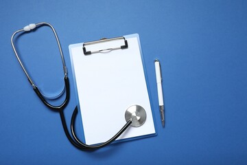 Stethoscope clipboard on color background, top view