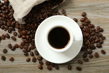 Cup of coffee and coffee beans on wooden background