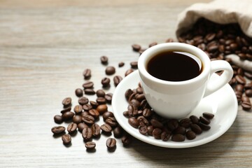 Cup of coffee and coffee beans on wooden background