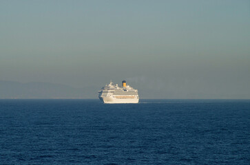 Modern Italian family cruiseship cruise ship liner Fascinosa at sea with coast line, mountain range and coastal cities seascape landscape ocean view