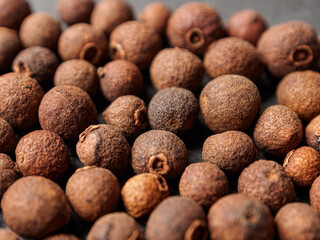 A close-up of black allspice, highlighting the texture and rich color