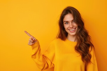 Fototapeta premium Cheerful girl pointing at empty space in colorful background.