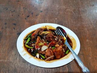 close up of delicious soy sauce chicken sitting on a white plate.