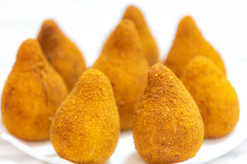 Traditional fried coxinha on a wooden table in selective focus - Brazilian snack
