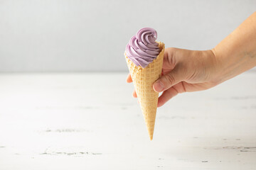 Vanilla berry soft ice cream in a  in waffle cone on a white background