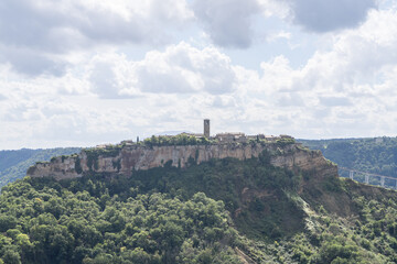Fototapeta premium Bagnoregio, Italy - September 28 2024: Panoramic view on Civita di Bagnoregio. Picturesque Ancient Hilltop Etruscan era village with Historic Architecture and Stunning Panoramic Views. Italian summer.