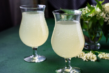 Carbonated elderflower drink. Flower summer kvass in glasses. Sparkling homemade hugo water.