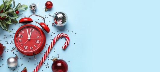 Alarm clock and decorations on light blue background with space for text. Christmas countdown...