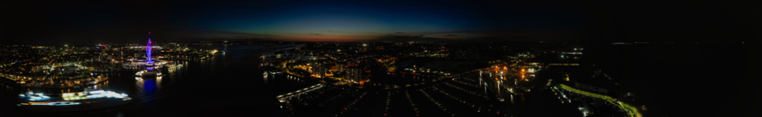 High Angle Night Panoramic View of Illuminated Portsmouth Central City Docks on Ocean Edge at Just After Sunset Time England United Kingdom. Drone Camera Footage Captured on Night of May 15th, 2024