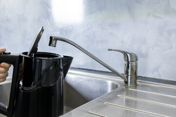 Electric kettle filling with tap water from kitchen sink, Daily water boiling preparation process