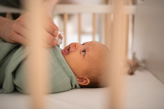 Parent giving pacifier to newborn