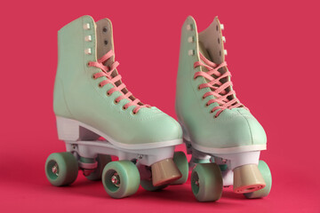 Pair of vintage roller skates on pink background