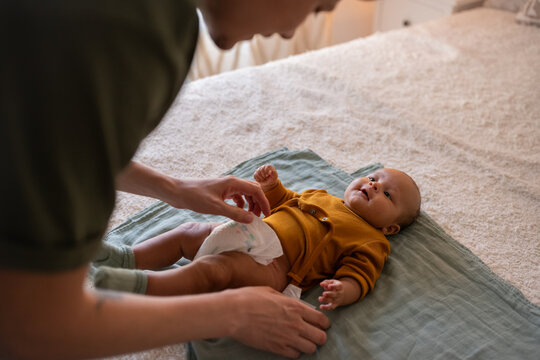 Father changing diaper to newborn