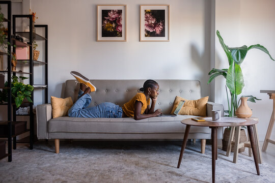 Candid woman working using laptop on couch