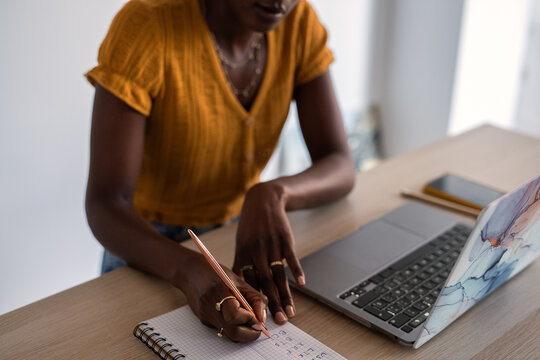 Woman writing cryptocurrency codes in notebook