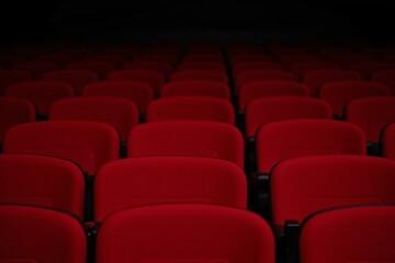 Fototapeta premium Auditorium's Solitary Wait: Rows of Vacant Seats, Anticipation, Silence, Red Velvet, Darkness, Stage, Vacancy, Expectation, Comfort, Warmth, Showtime, Lights, Empty