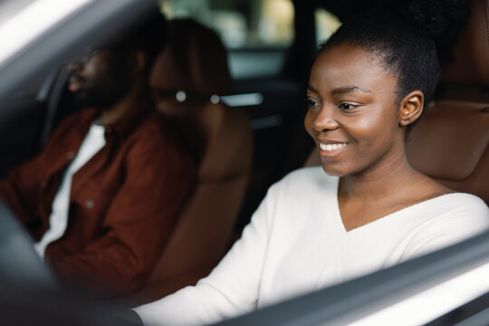 Woman seated in vehicle beside her friend preparing for test drive