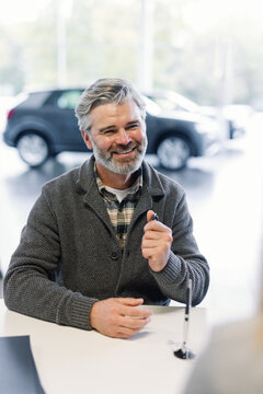 Buyer rejoicing after signing vehicle purchase contract with sales rep